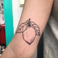 a black and white photo of a lemon tattoo on the arm