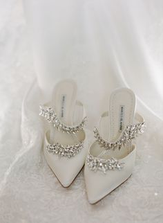 the brides white shoes are adorned with crystal jewels