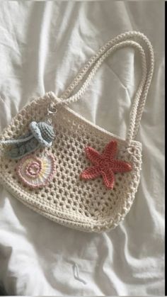 a crocheted purse with starfish and seashells hanging from it's handle