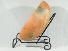 an orange object sitting on top of a metal stand