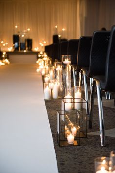 rows of candles are lined up along the aisle