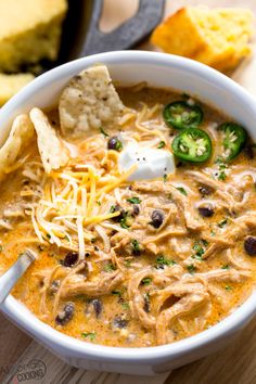 a bowl of instant pot white chicken chili with tortilla chips and sour cream