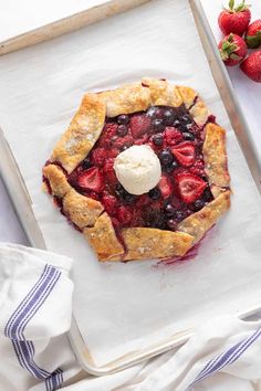 a berry pie with ice cream on top and strawberries in the background text reads summer berry galette