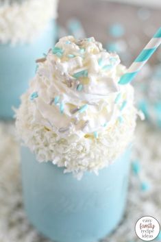 cupcakes with white frosting and sprinkles in blue cups