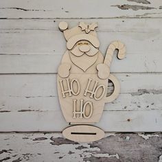 a wooden cutout of a santa clause holding a candy cane with the words ho ho ho on it