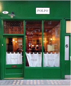 the front door of a restaurant with two white bags in it's windows