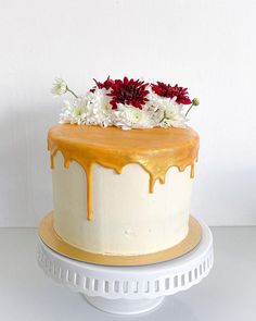 a cake with white and yellow icing, flowers on top is sitting on a plate