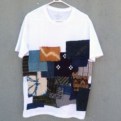 a white t - shirt with multicolored patchwork on it