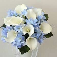 a white vase filled with blue and white flowers