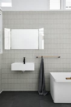 a white bathroom with two sinks and a bathtub in it's center area