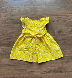 "Beautiful handmade baby girl, toddler, Girl dress is a Retro style , flutter sleeve, custom dress made from bright yellow bumblebee print cotton fabric. The dress buttons in the back, it also ties in the back (smaller sizes have shorter ties) All seams are finished. Sewn with great care. Boutique quality sewing. If you need the length of the dress to be different please include a message with order. Measurements: Size, chest, waist, length, 3 months length 12.5\". 6 months, length 14.5\". Size, Playful Yellow Twirl Dress For Spring, Cute Yellow Twirl Dress For Summer, Cute Yellow Twirl Dress For Spring, Cute Yellow Summer Twirl Dress, Yellow Fitted Dress With Flutter Sleeves, Yellow Flutter Sleeve Dress With Ruffles, Playful Yellow Short Sleeve Dress, Bee Dress Women, Playful Yellow Dress With Ruffles