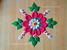 a close up of a flower made out of felt on top of a wooden table