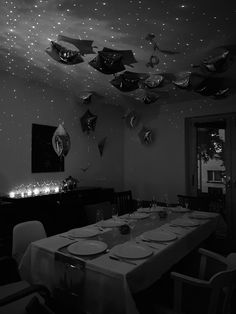 black and white photograph of a dining room with stars on the ceiling, table set for four