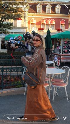 a woman is walking down the street with her hand on her hip and holding a purse