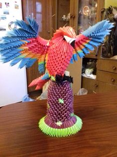 a colorful bird sculpture sitting on top of a wooden table