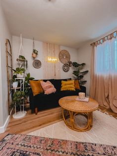 a living room with a black couch and wooden coffee table in front of a window