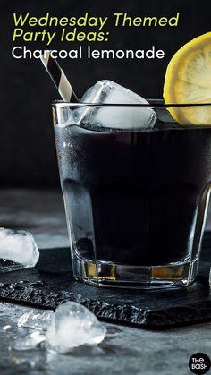 a black drink with ice and lemon wedges