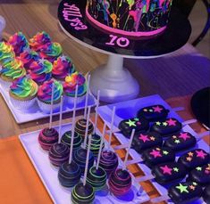 there are many cupcakes on the table with colorful frosting and stars around them