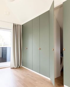 an empty room with green cabinets and sliding doors