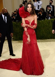 an image of a woman in red dress at the mete awards ceremony with cameras around her