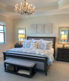 a bedroom with a large bed and chandelier hanging from it's ceiling