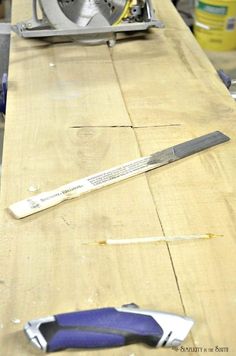 a knife is laying on top of a table with some other tools around the edge