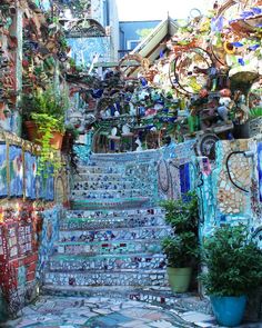 the stairs are covered with mosaic tiles and potted plants