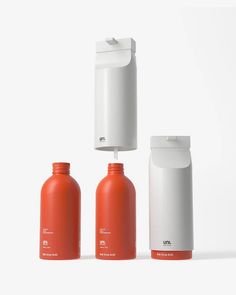 three orange and white bottles sitting next to each other in front of a white background