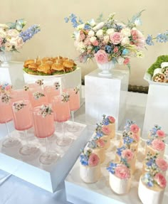 a table topped with lots of glasses filled with drinks and desserts on top of it