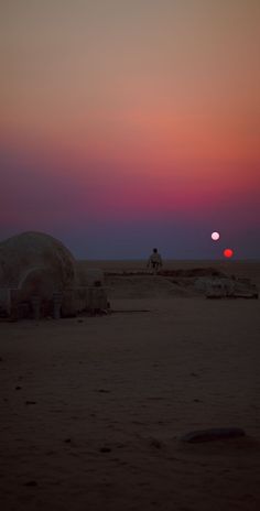 the sun is setting over some sand structures