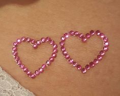 two pink heart shaped jewels on the stomach