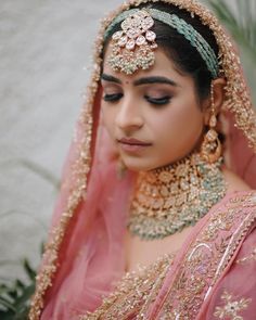 a woman wearing a pink outfit and gold jewelry