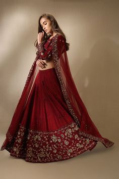 a woman in a red and gold lehenga