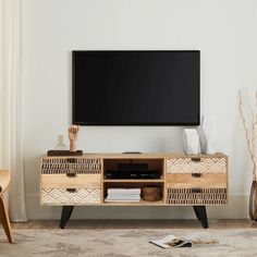 an entertainment center with a flat screen tv mounted on it's sideboard in a living room