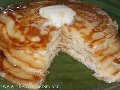 pancakes with butter and syrup on a green plate, cut in half to show the filling