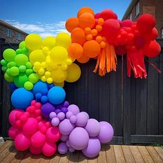 there is a bunch of balloons in the air on the ground next to a fence