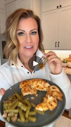 a woman holding a plate with food on it