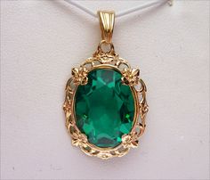 This is a gorgeous pendant! Perfect for any May baby or women with dark hair! The pendant boasts a beautiful 16x12 oval cut synthetic green stone. It has a beautiful emerald green color and is prong set into the mounting. The setting is a filigree design with floral inspiration. The top of the pendant has a scalloped V shaped bail. Pendant measures just over 1 inch long. Pendant is stamped 10k and weighs 2.9 grams. *We are always willing to ship internationally! Please message us for a quote! Green Oval Pendant Jewelry For Formal Occasions, Green Oval Large Pendant Jewelry, Women With Dark Hair, May Baby, Emerald Green Color, Smokey Topaz, Diamond Wedding Sets, Filigree Pendant, Floral Inspiration