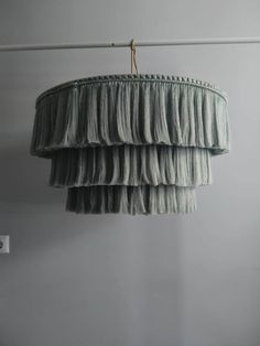 three tiered chandelier hanging from the ceiling in front of a white wall