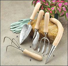 gardening utensils and garden gloves are arranged on a rock