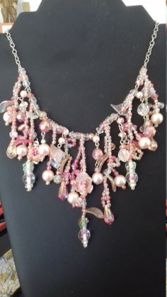 Magnificent and important necklace of pearls of different shades, materials and shapes, but always pink in color. There are beads in the shape of flowers, leaves, square, drop-shaped, round. All these pearls mounted together on a silver metal chain form a whole giving an appearance of lightness and preciousness. This necklace can, however, be offered or worn on the occasion of holidays such as: Christmas, New Year's Day, Valentine's Day, Mother's Day, etc. You will not see identical necklaces be Colored Pearl Necklace, Shell Crowns, Pink Pearl Necklace, Hippie Necklace, New Year's Day, St Valentin, Flowers Leaves, Pink Pearl, Pearl Color