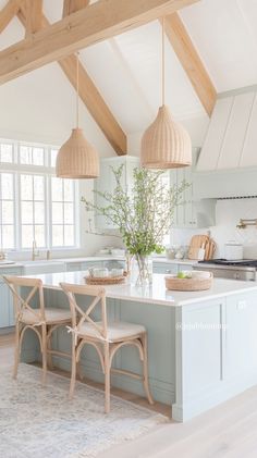 a kitchen with two chairs and a center island in the middle, surrounded by wooden beams