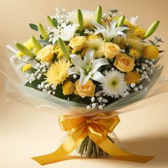 a bouquet of yellow and white flowers on a beige background with a ribbon around it