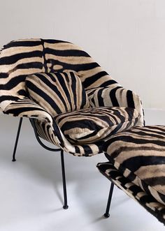 a zebra print chair and footstool are sitting in front of a white wall