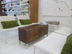 a living room with two white chairs and a wooden trunk