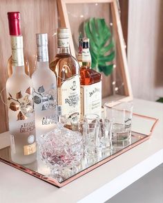 several bottles and glasses sitting on a tray