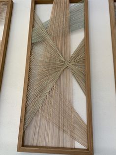 two wooden frames with string art hanging on the wall