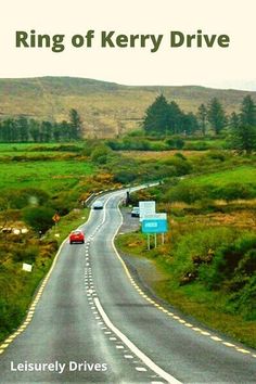 the road is lined with green grass and trees on both sides, as well as two blue signs that read ring of kerry drive