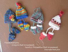 crocheted hats and mittens are arranged on the wall next to each other