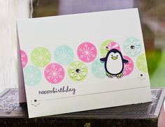 a card with a penguin and snowflakes on it sitting on top of a table